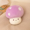 A purple mushroom plush pillow with white spots and a round white body resting on a beige fabric.