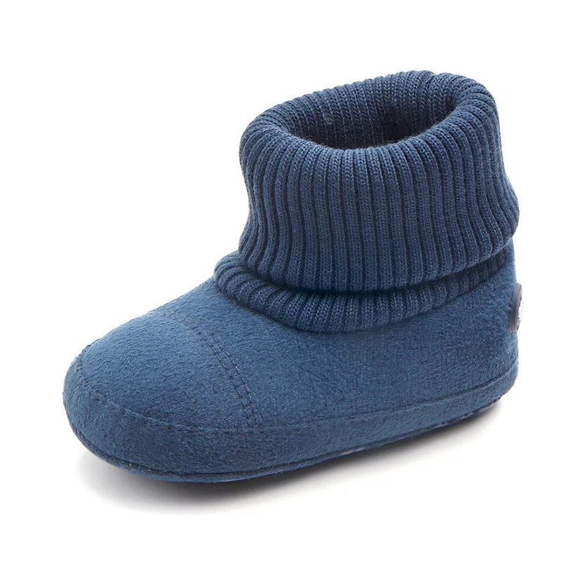 A navy blue baby winter snow boot with a ribbed cuff and fuzzy ball accents.