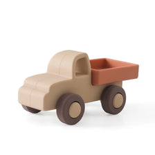 A beige silicone toy truck with an orange cargo bed and round wheels.