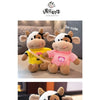 A soft, adorable plush toy of a cow with black and white markings, featuring pink and yellow clothing.