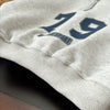 A light gray kids sweater with a large blue number 19 and the text 'THE SPORT' is shown on a dark background.