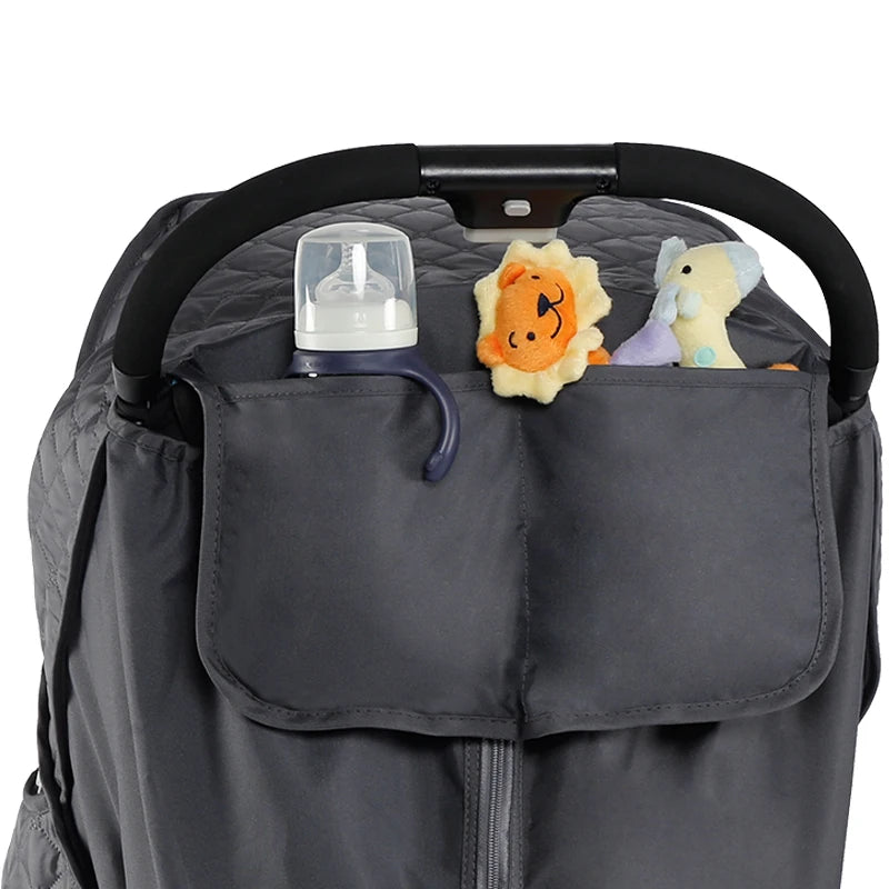 A gray waterproof stroller cover with a black handle shows several stuffed animals inside.