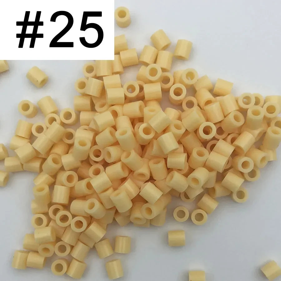 A pile of 1000 small, light yellow or beige plastic fuse beads for craft projects.