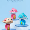 Four color matching options of turtle and dolphin shaped water guns displayed on white stands.