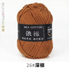 A ball of brown milk cotton yarn labeled with Chinese characters and the size 26 needle gauge.