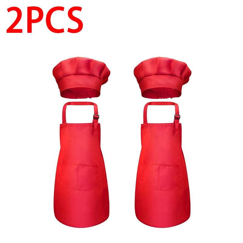 A pair of red kids' chef apron and hat set displayed side by side.