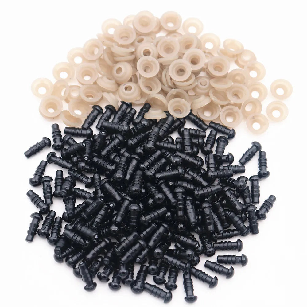 A pile of black plastic safety eyes with washers and a pile of beige plastic eyes.