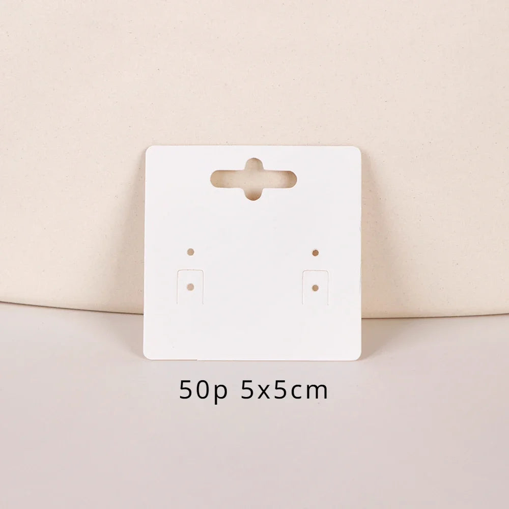 A white square jewelry display card with a cutout and two holes is shown on a light background.