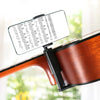 A black clamp holder is attached to a guitar, displaying sheet music on a smartphone screen.