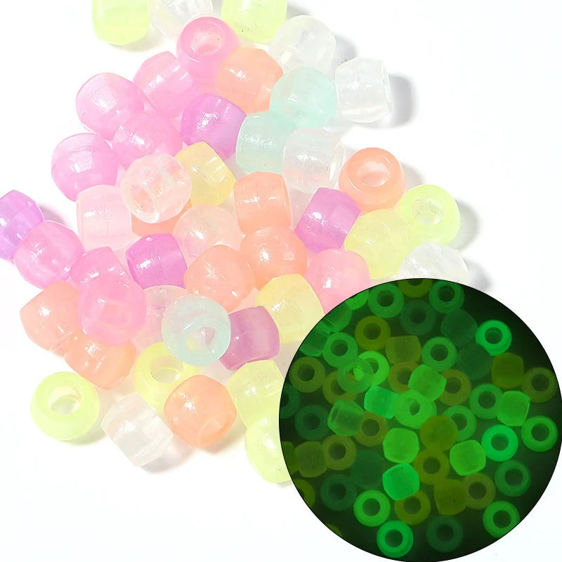 A pile of colorful pony beads in pink, yellow, and clear shades for jewelry making