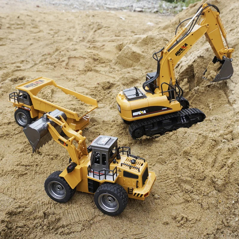 A yellow die-cast toy excavator construction vehicle digging in sand.