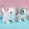 Two plush cat toys, one white and one gray, are displayed on a light blue surface.