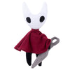 A white, stylized plush doll resembling a masked creature with black accents and a dark red cape.