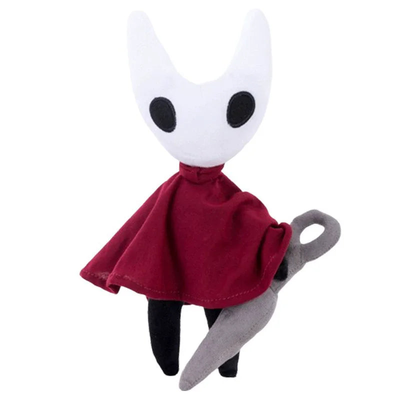 A white, stylized plush doll resembling a masked creature with black accents and a dark red cape.