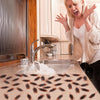 A woman is shown aggressively using lifelike fake cockroach props in a kitchen setting.