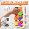 A hand interacts with a Montessori power strip designed to prevent toddlers from touching dangerous electrical devices.