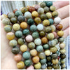 A hand holds a strand of natural stone beads including amethyst, garnet, and labradorite for DIY jewelry making.