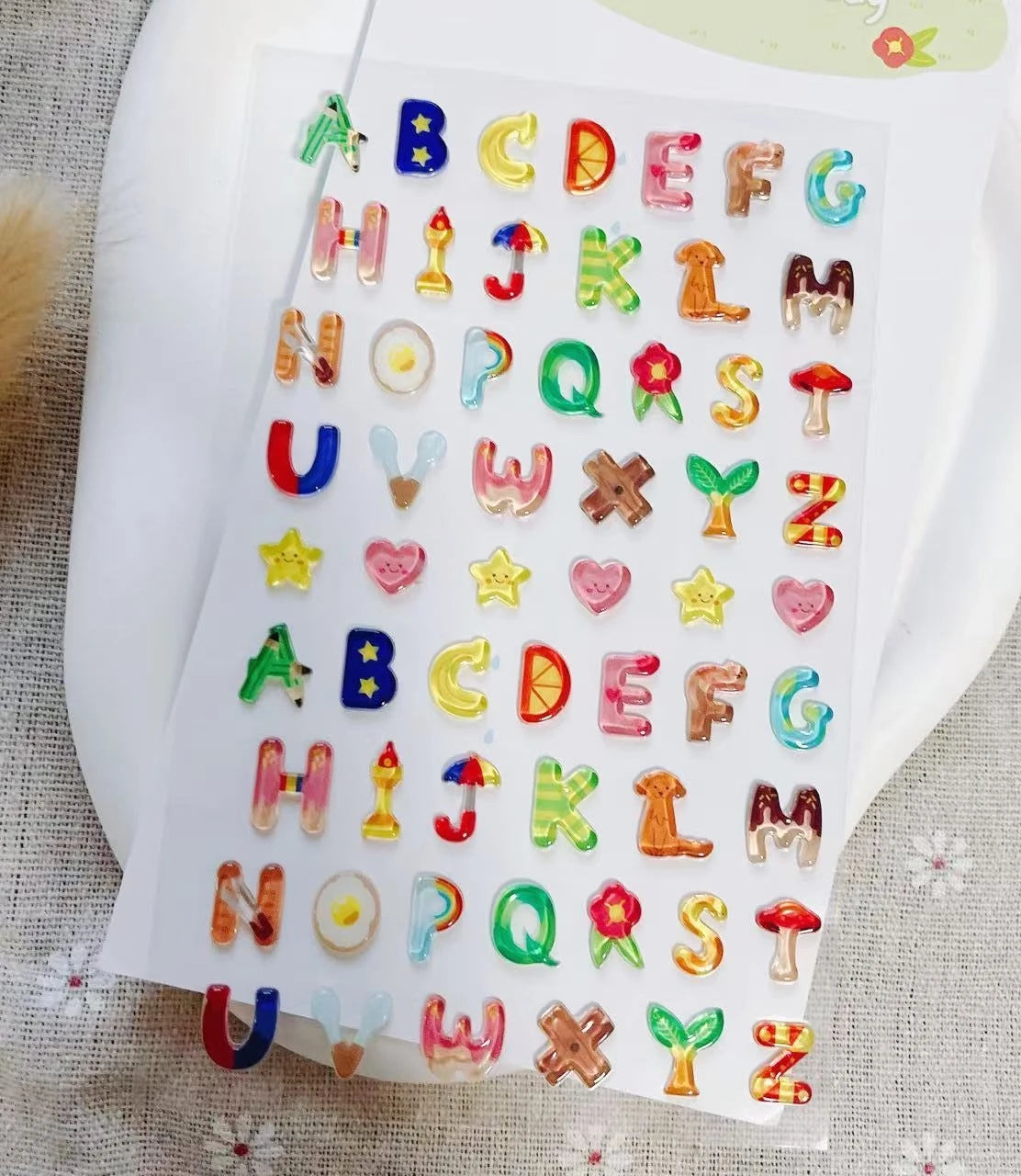 A sheet of colorful 3D smile face crystal stickers in alphabetical order for crafting and decorating