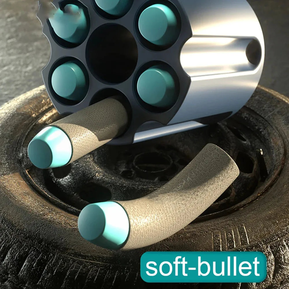 A close-up view of a soft-bullet toy pistol with rapid-fire action mechanism resting on a dark surface.