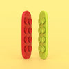 Deux bandes anti-stress en silicone, une rouge et une vert lime, sur fond jaune clair.