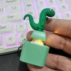 A green frog-like fidget toy with an LED light is clipped onto a teal keychain.