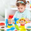 A toddler is playing with a colorful color dough haircut playset featuring various tools and hair figures.