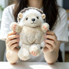 A person is holding a light beige and white cute hedgehog plush pillow.