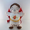 A plush toy depicting a baby with a hood and a red cape, featuring warm light accents.
