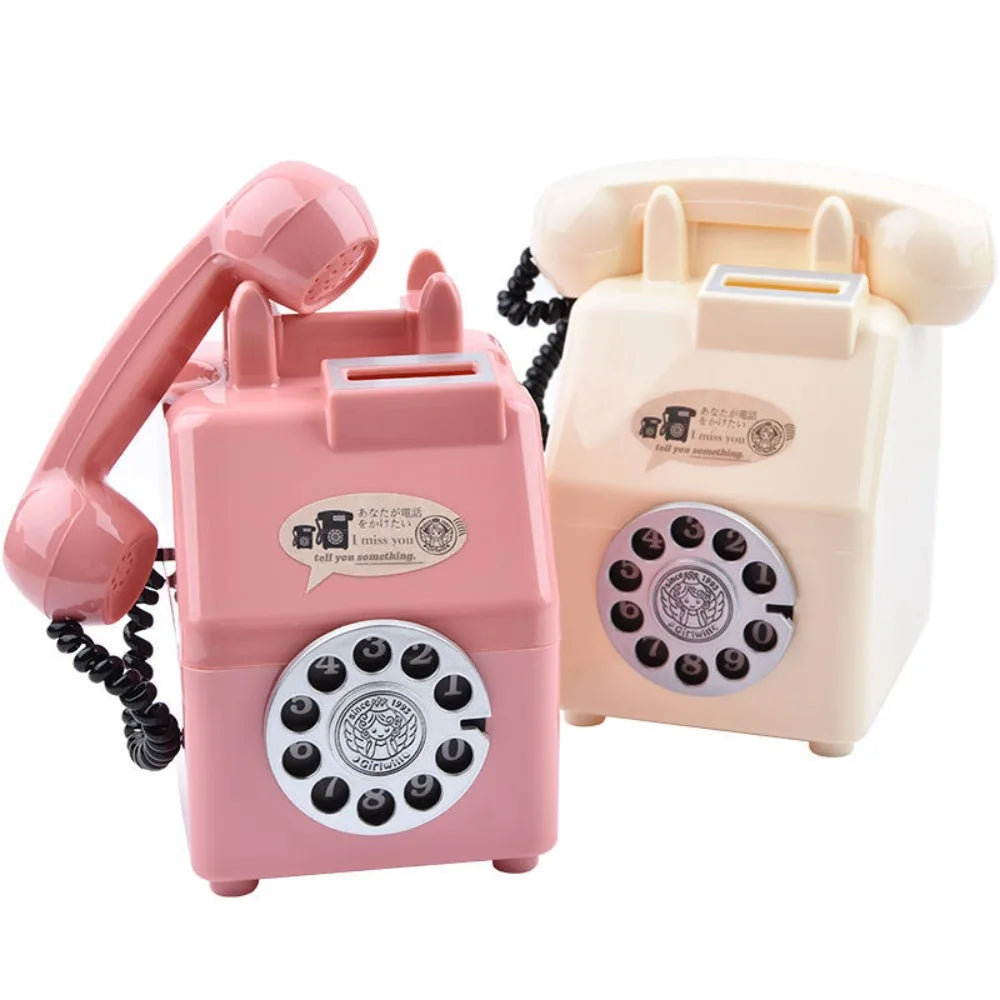 A pink vintage rotary telephone piggy bank with a handset and a cream-colored version.