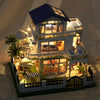 A detailed diorama of a DIY wooden mini seaside villa dollhouse kit featuring furniture and landscaping.