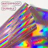 A roll of holographic vinyl with water droplets visible, showing iridescent colors and a glossy texture.