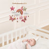Handmade felt butterfly crib mobile with stars and a rainbow hanging above a baby's crib