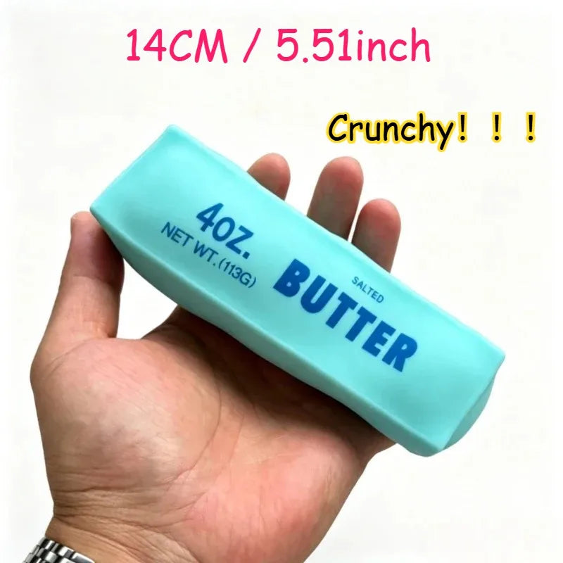 A hand holds a light blue squishy stress ball labeled 4oz salted butter with the text Crunchy