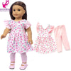 A doll wearing a pink floral dress and matching pink pants.