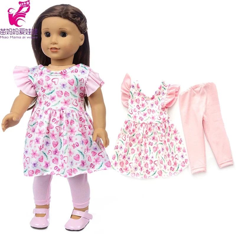 A doll wearing a pink floral dress and matching pink pants.