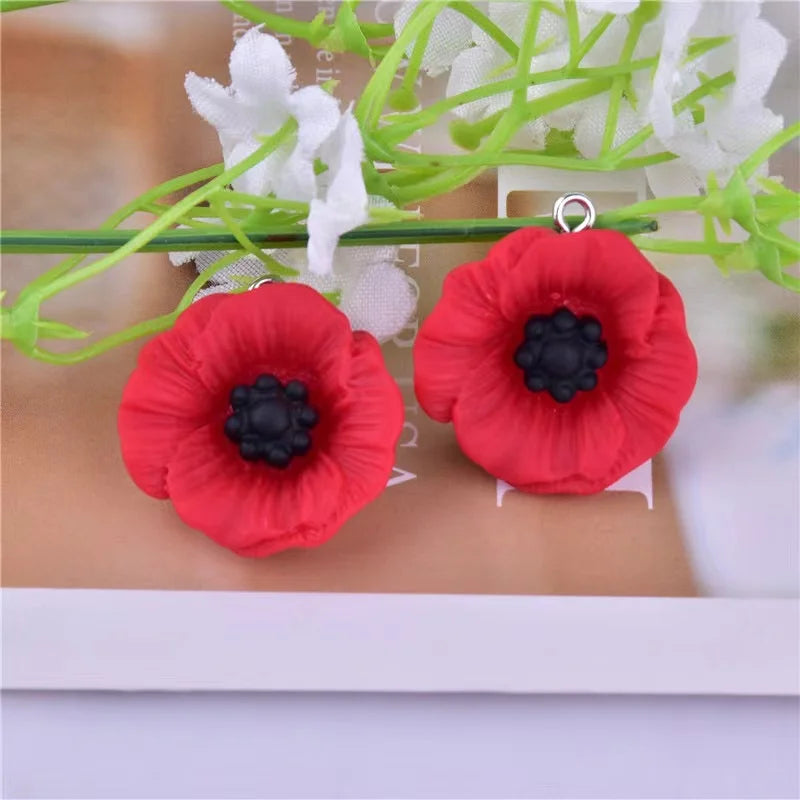 Red felt flower charms resembling sunflowers with black centers on a green stem