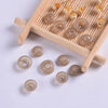 A collection of clear plastic safety eyes in various sizes and shades arranged on a wooden tray.