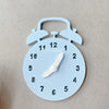 A light blue wooden Montessori clock with castle and bulldozer shapes on the face