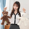 A woman holds a fluffy white teddy bear plush pillow with a bow in her hands.