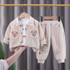 A beige corduroy tracksuit set for a child, featuring a jacket and matching pants, displayed on a hanger.