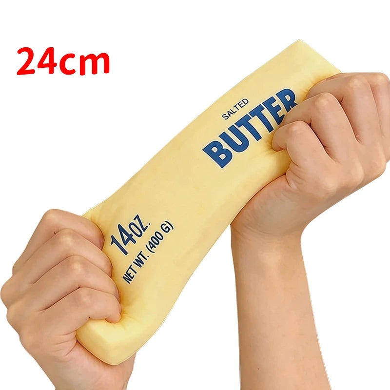 A hand holds a yellow salted butter stick fidget toy with a 24cm length and a net weight of 140g.
