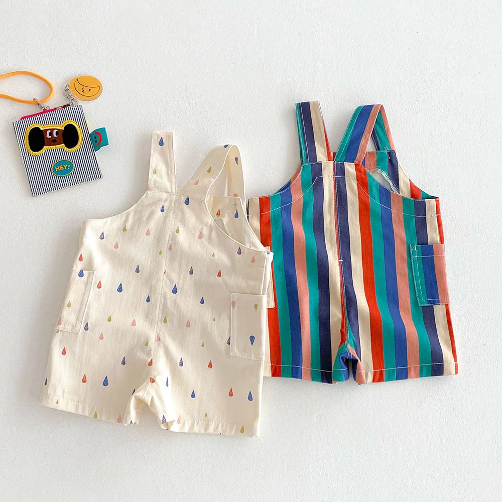 A pair of colorful striped kids overalls featuring a raindrop print, laid flat on a white surface.
