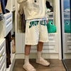 A person wearing a cream hoodie and white shorts with green trim stands in a store display featuring comfortable EVA platform