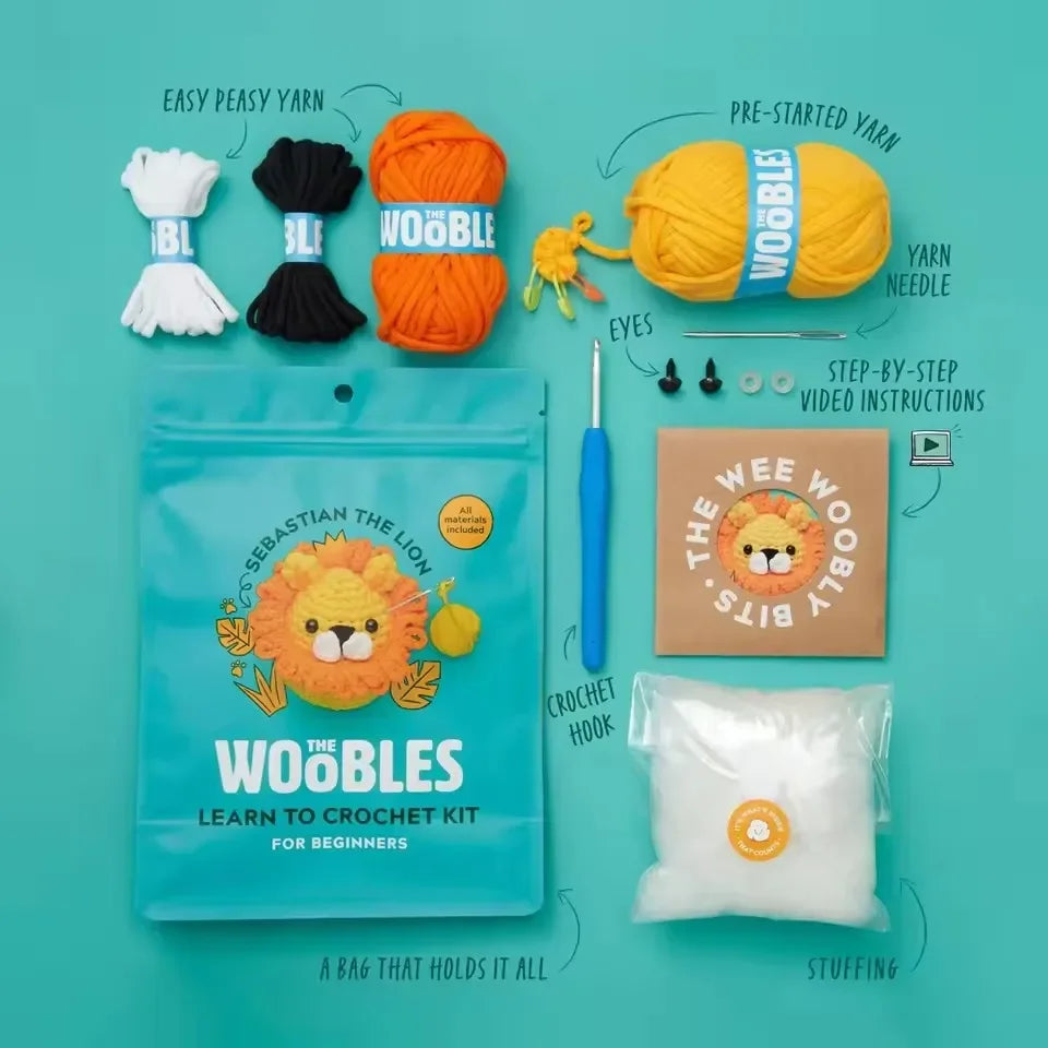 A collection of yarn, needles, and accessories for a beginner crochet kit featuring lion and animal toys.