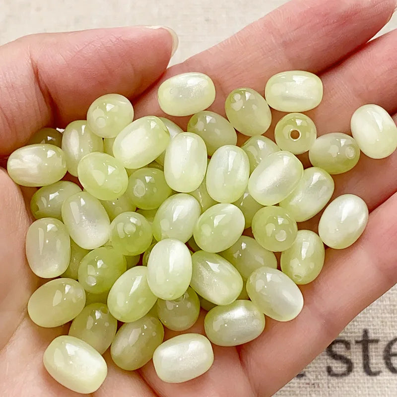 A handful of pale yellow to translucent green resin starry sky cat's eye beads for jewelry making
