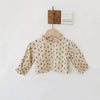 A light beige vintage floral baby girl outfit set featuring a blouse and romper, hanging on a wooden hanger.