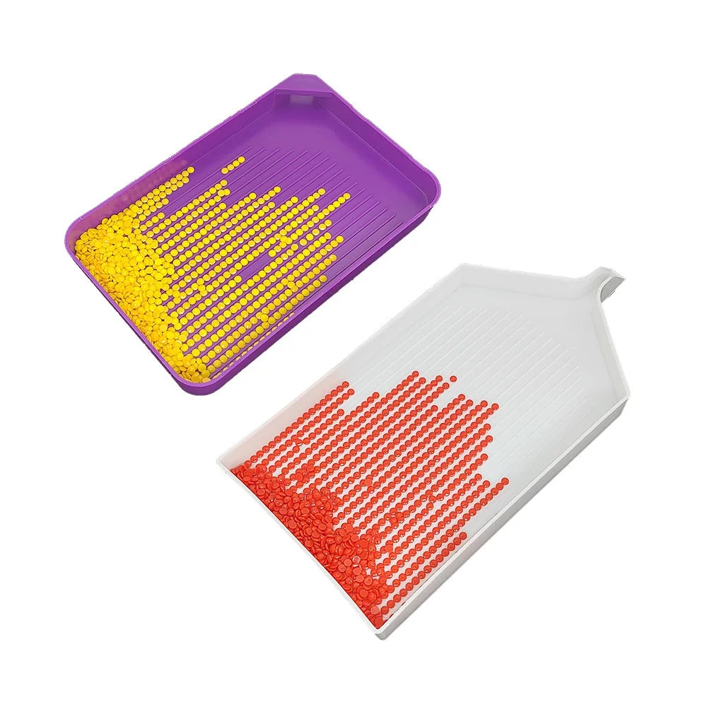 A purple diamond painting tool kit showing a tray filled with yellow and red beads.