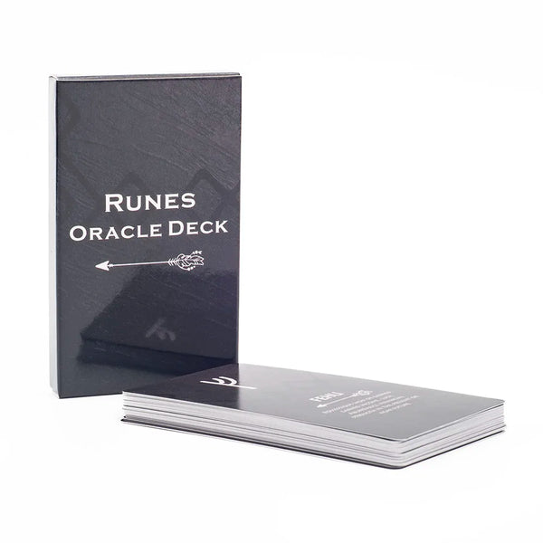 Une boîte noire et une pile de cartes pour un jeu de divination Runes avec du texte blanc sur la face.