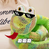 A bright green cartoon snake plush toy with large eyes wearing black sunglasses