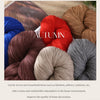 A collection of various colored yarn skeins in shades of brown, red, blue, and gray for knitting projects.